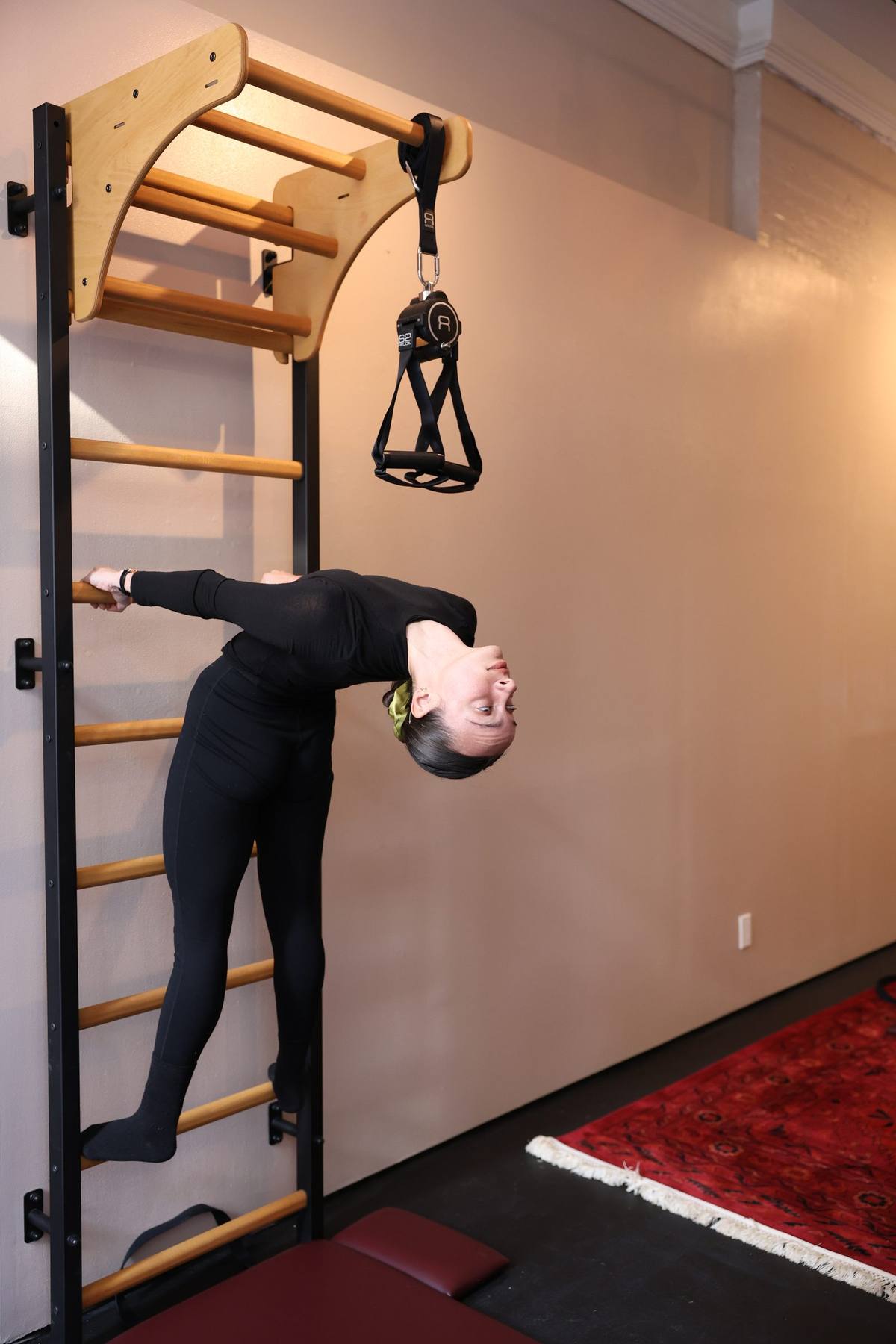 Advanced wall bar exercise at Praxis Pilates NYC — demonstrating exercises impossible on a flat wall